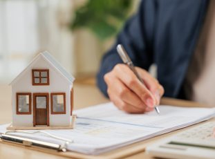 A,Man,Writes,A,Signature,On,House,Insurance,Documents,,Using